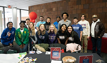 Students in UDM Greek life pose for a photo in the Fountain Lounge.