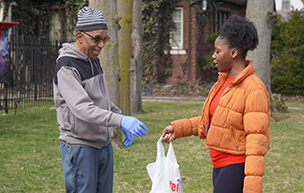 A TENN student delivers a bag of food to a community member.