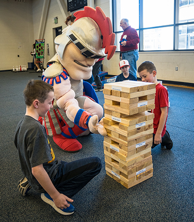Tommy plays giant Jenga with children at the Titan Winter Blast.
