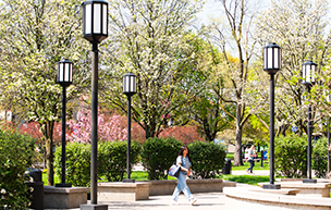 A student walks on the McNichols Campus during springtime.