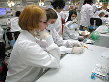 Photo: UDM dental student discusses indirect vision to Boys Club member at "Dentist for a Day."