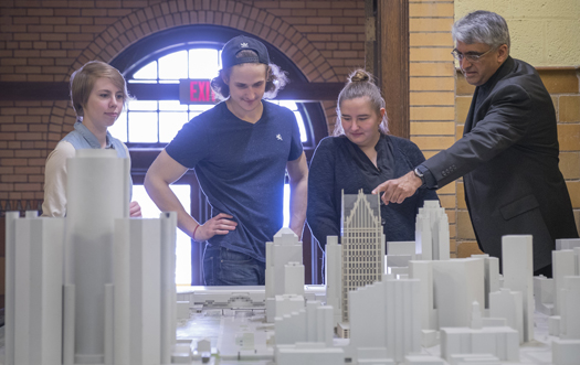 Fr. Gilbert Sunghera of Detroit Mercy's School of Architecture (SOA) offers help to a group of students working on a project. The Detroit Collaborative Design Center, which is run through the university's SOA, provides students, organizations, companies and other constituents expertise regarding architectural and community development projects.