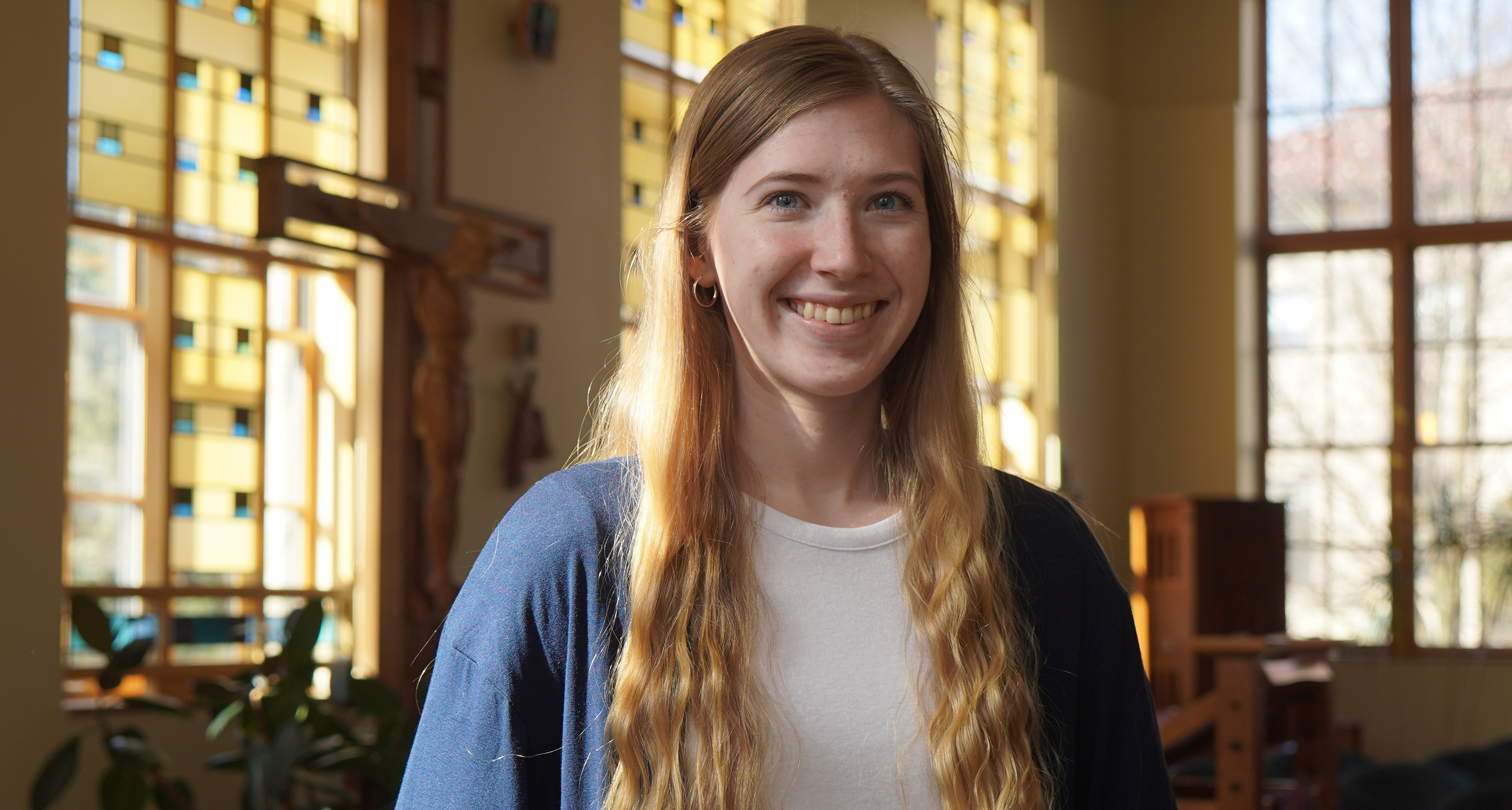 MacKenzie Patterson stands smiling inside of the St. Ignatius Chapel.