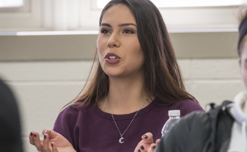 female student explaining something in class