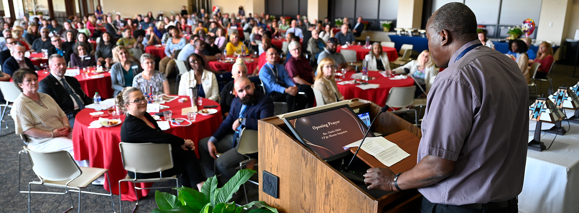 A wide shot of many employees gathered and conversing in the Ballroom for the Spotlight on Excellence event.