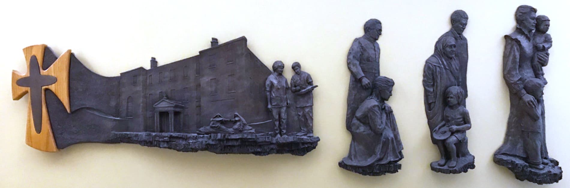 A sculptured wall-hanging featuring the House of Mercy in Dublin, Catherine McAuley, and people helping children