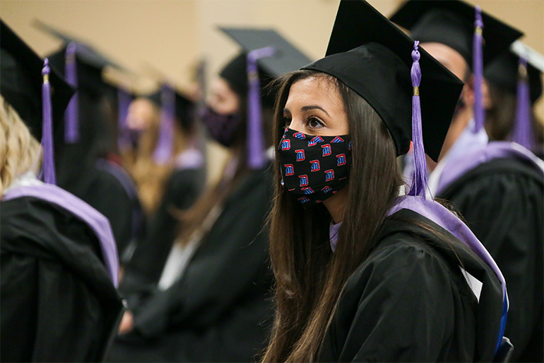 Class of 2021 dental hygiene graduate sits socially-distanced during the ceremony.