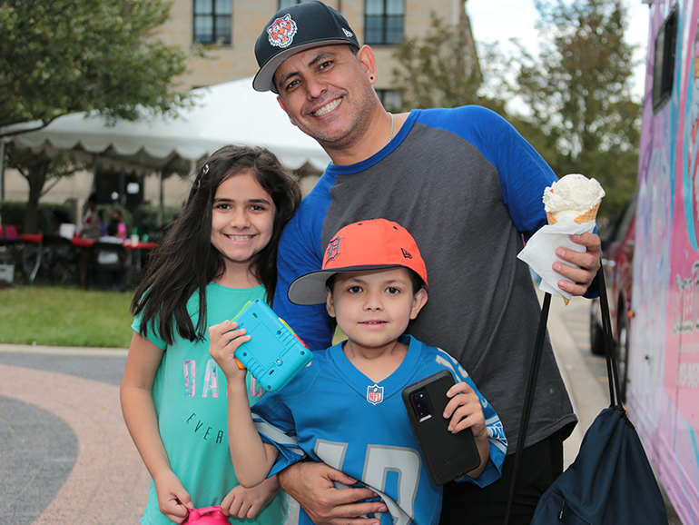 Homecoming 2021 was a family affair for a man and his children, who enjoy an ice cream from one of the food trucks at the event.