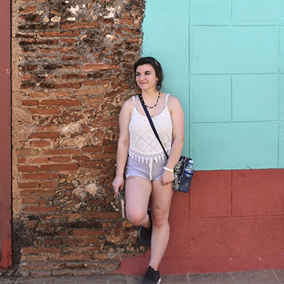 Taylor Kile poses for a photograph next to a wall in Cuba.