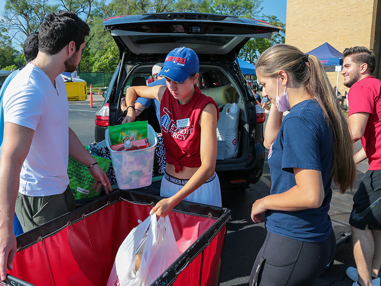 A group of students unload a vehicle during move-in day.