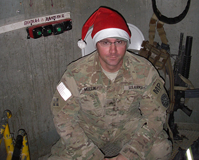 A photo of Alan Mullin, who is wearing a Santa hat, from his time serving in the military.