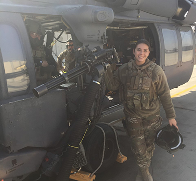 A photo of Jessica Dailey next to a helicopter while serving in the military.