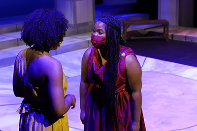 Jade Sibert, left, as Ismene and Kaelyn Johnson as Antigone, discuss betraying the king to bury their brother.