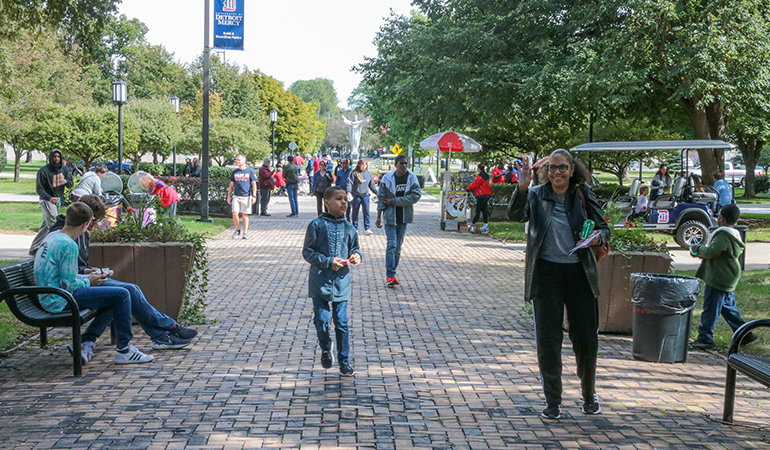 People walk around the McNichols Campus on a sunny day during Homecoming 2022.