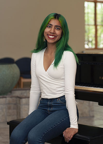 Mehar Soni sits on a piano stool inside of the St. Ignatius Chapel.