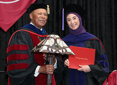 President Antoine M. Garibaldi presents Fatmeh T. Cheaib with the Vivere ex Missione award during commencement.