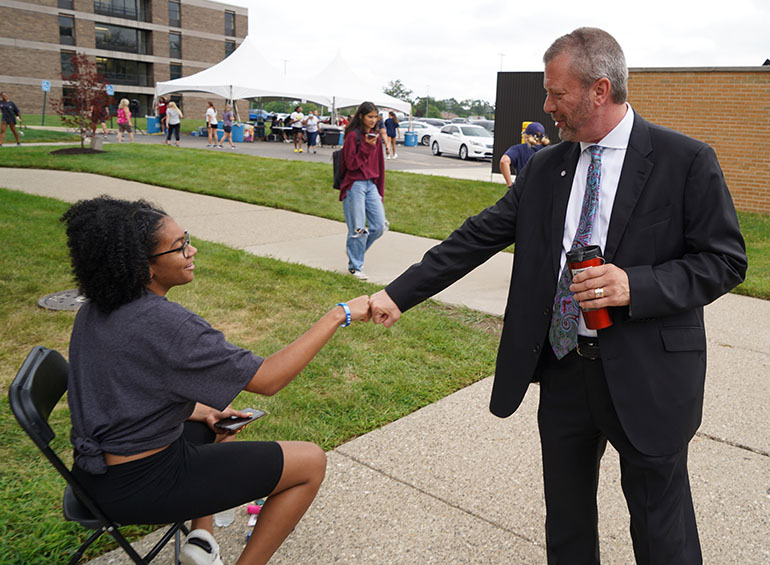 President Taylor fist bumps a student during freshman move-in day.