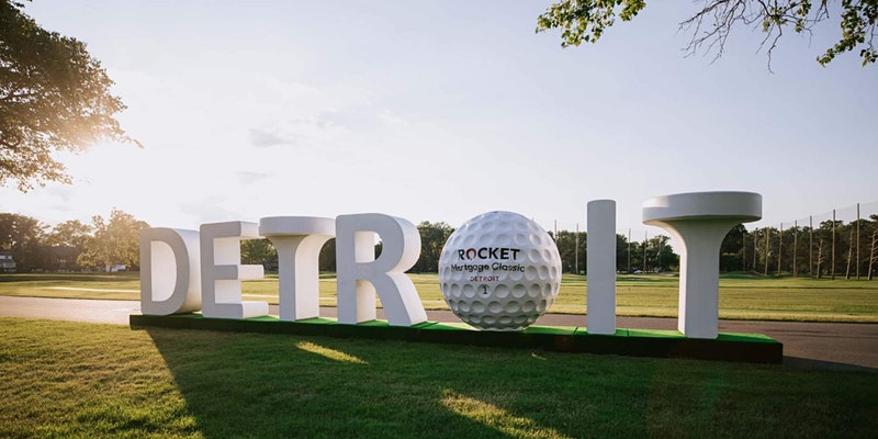 A promo image for the Rocket Mortgage Classic, which features large, white letters, a golf ball and tee that spell out Detroit.