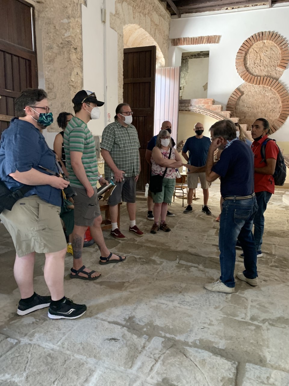 Members of the 2022 immersion trip to Cuba listen to a guide inside of a school.