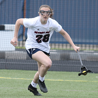 Women's lacrosse student-athlete Kaileigh Nuessgen moves up the field with the ball during a match at Titan Field.