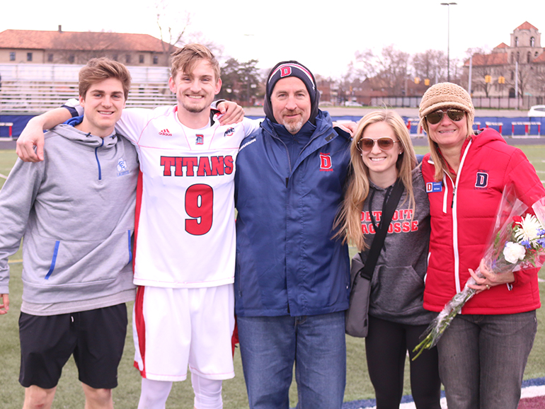 Birney family members stand on Titan Field for a photo on a Senior Day.