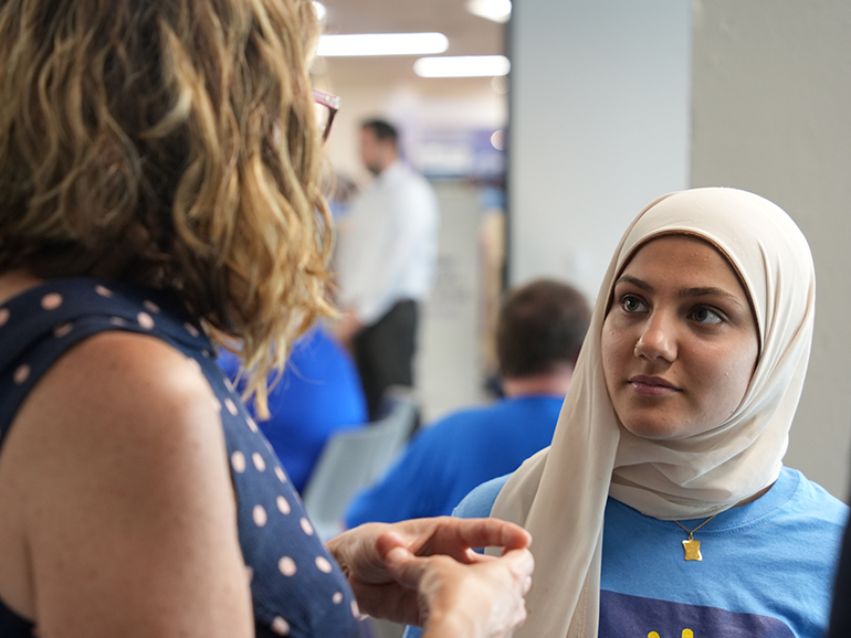 A student listens to a Dean talk inside of the Student Union.