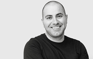 Mark Haidar smiles in this black and white photo.