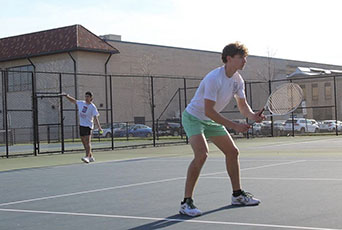 Members of the UDM tennis club team play on the courts on the McNichols Campus.