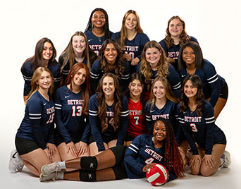 Members of the women's volleyball club team gather close to each other for a team photo.