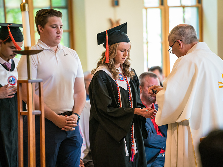Graduates and guests line up to receive communion during the Baccalaureate Mass.