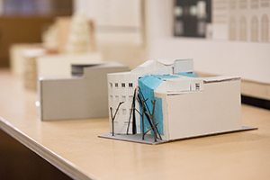 Models of buildings are positioned on a table.