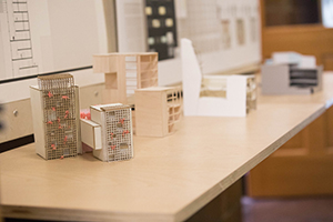 Models of buildings are positioned on a desk.