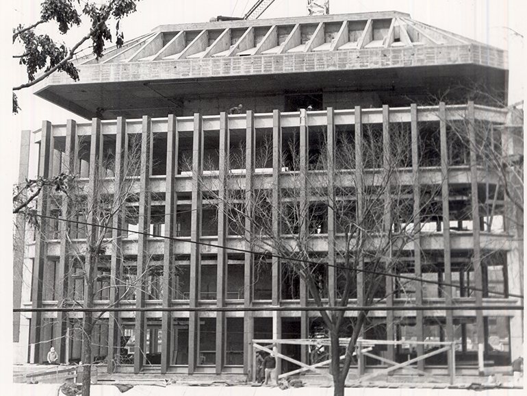 A black and white photo of the Fisher Building being constructed.