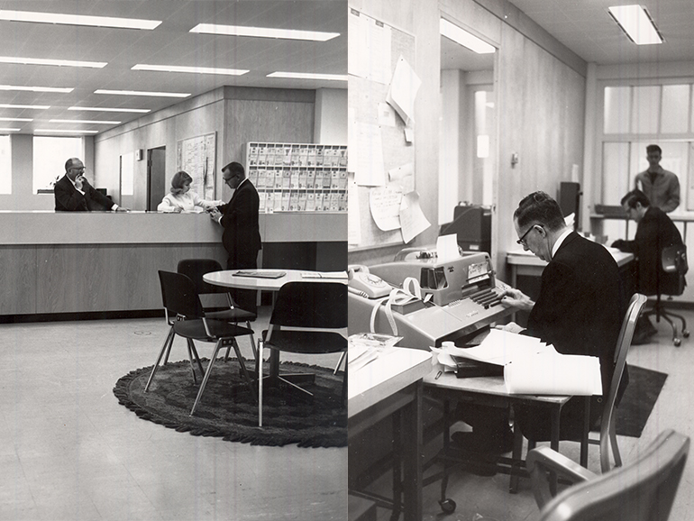 A black and white photo showcases six individuals working inside of the Fisher Administration Center.