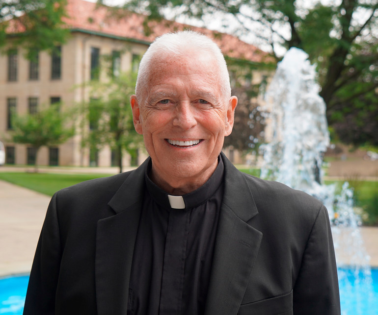 Fr. Patrick Dorsey smiles outdoors.