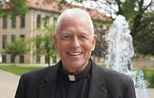 Fr. Patrick Dorsey smiles outdoors.