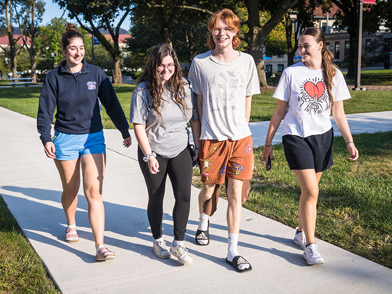 Four students walk campus during UDM's Homecoming.