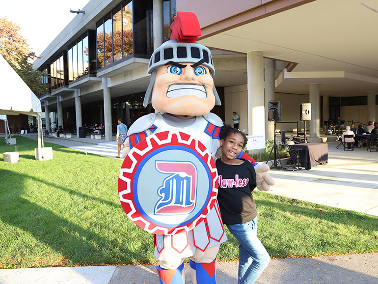 Tommy Titan poses for a photo with a child.