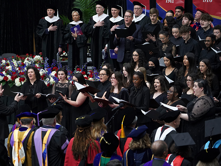 More than two dozen people sing during a choral song.