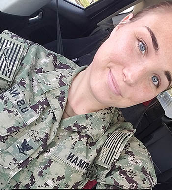 Lauren Harman takes a selfie in a vehicle while wearing her fatigues.