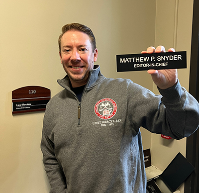 Matthew Snyder holds his Law Review nameplate that reads Matthew P. Snyder, editor-in-chief.
