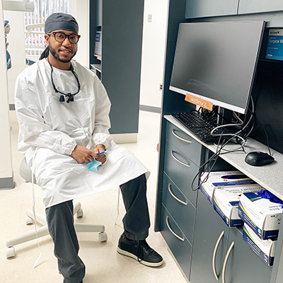 Trey Hester sits in a dental clinic station, ready to work.