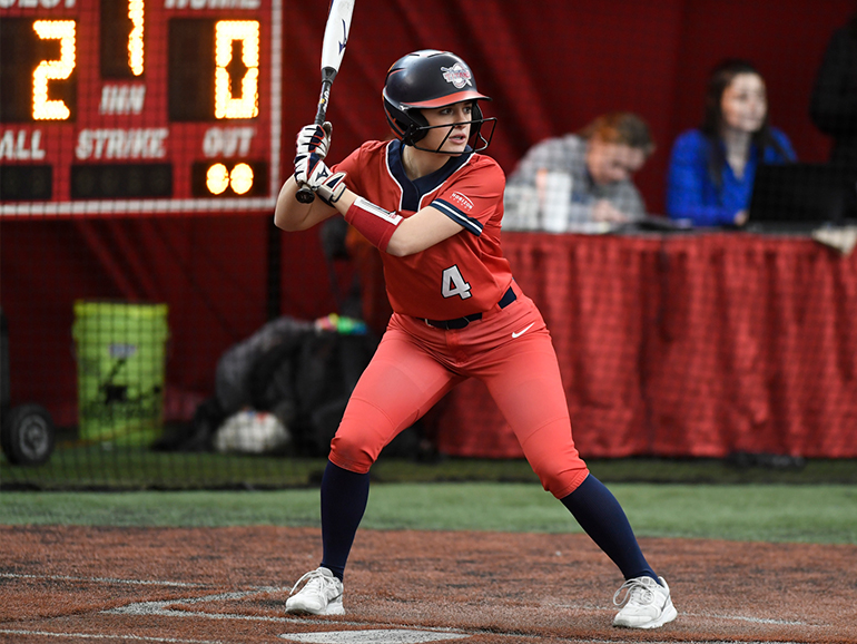 Kara Wolfbauer wearing a Detroit Mercy #4 softball uniform bats at the plate during a softball game.