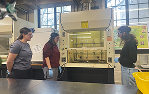 Three students work in a chemistry lab.