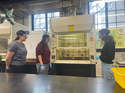 Three students work in a chemistry lab.