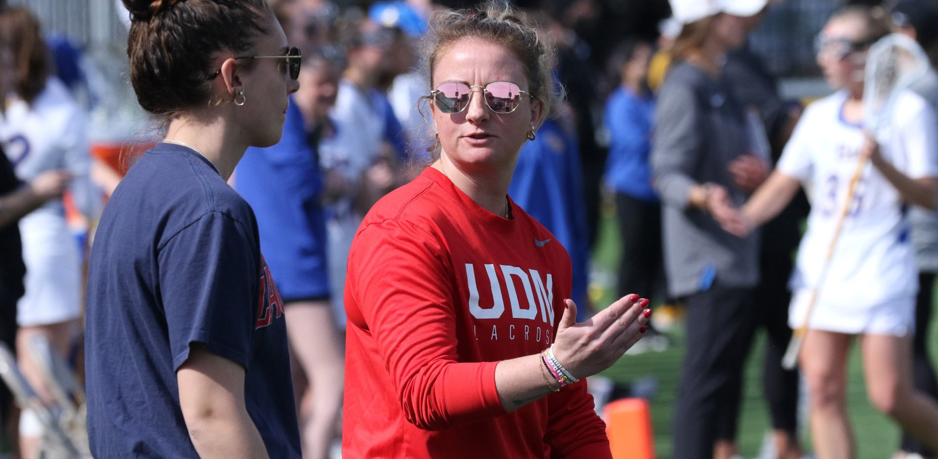 Madeline Dugan, right, talks to an assistant coach during a Titans women's lacrosse game.