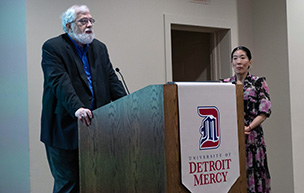 Roy Finkenbine speaks at the podium while Ilyon Woo stands next to him during Love Stories from the Underground Railroad in February 2024.