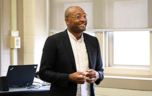 Justin Williams stands at the front of a classroom during a class.