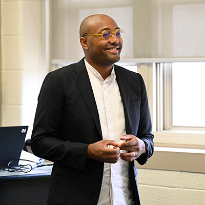 Justin Williams stands at the front of a classroom during a class.