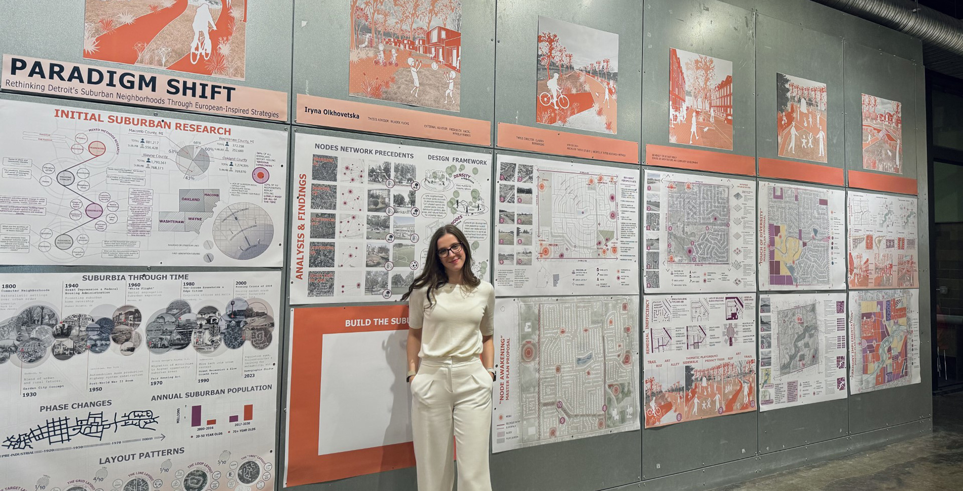 Iryna Olkhovetska poses in front of her thesis presentation, titled "Paradigm Shift: Rethinking the Notion of Detroit's Suburban Neighborhoods by Exploring European-Inspired Design Strategies." 